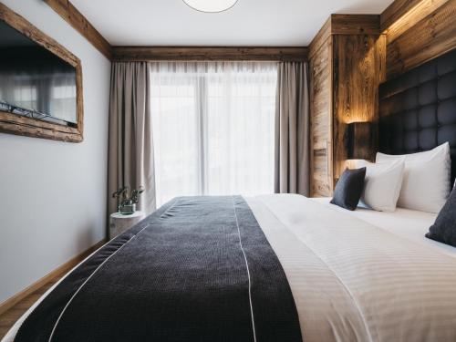 a bedroom with a large bed with a large window at VAYA Sölden inklusive Summer Card in Sölden