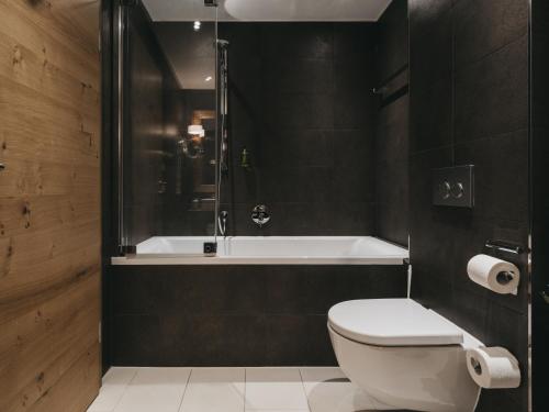 a bathroom with a toilet and a bath tub at VAYA Sölden inklusive Summer Card in Sölden