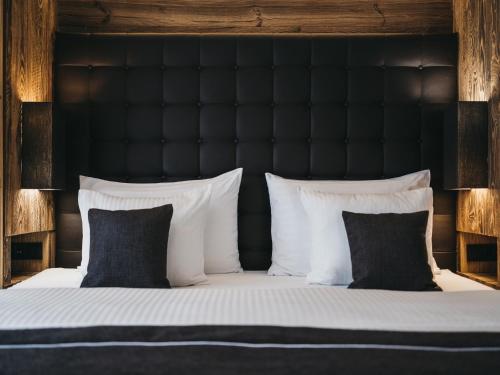a bed with a black headboard and white pillows at VAYA Sölden inklusive Summer Card in Sölden