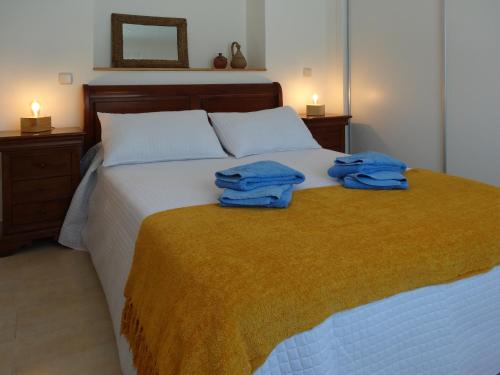 a bedroom with a bed with two blue towels on it at Casa Rural Mirando a la Peña "Grupo Mirando a Gredos" in Cadalso de los Vidrios