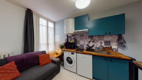 une cuisine avec des placards bleus et un canapé violet dans l'établissement Le Petit St Louis - Court et long séjour, à Versailles