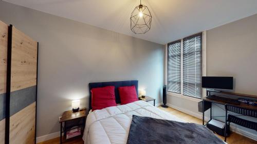 une chambre avec un grand lit avec des oreillers rouges dans l'établissement Le Petit St Louis - Court et long séjour, à Versailles