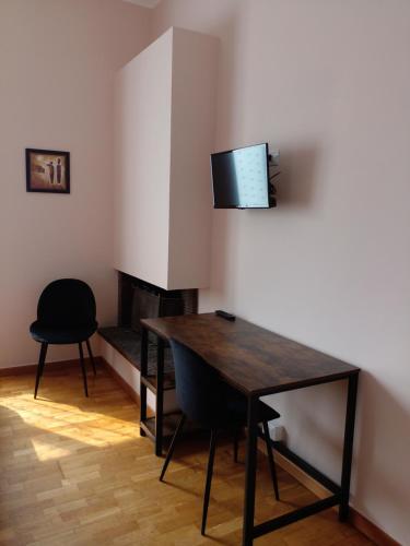 jadalnia ze stołem i telewizorem na ścianie w obiekcie La Magia Della Collina, Appartement de charme w Turynie