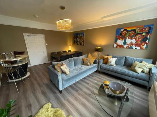 a living room with a blue couch and a table at Impeccable 4-Bed Apartment in Bath in Bath