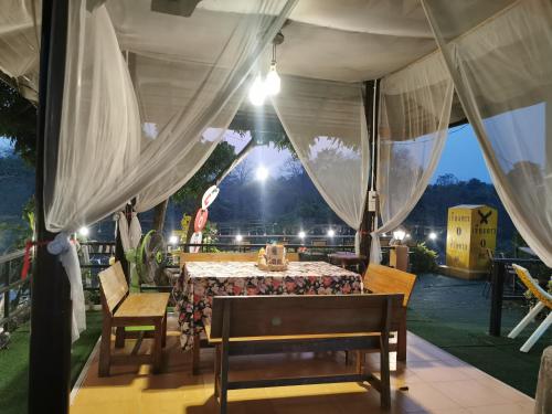 a dinner table in a tent with a view at Mon Kiang-Dao Resort in Chiang Dao