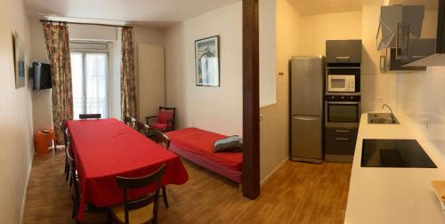 Habitación pequeña con mesa roja y cocina en Résidence Richelieu, en Barèges