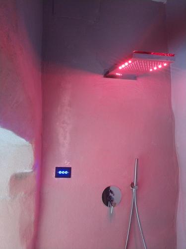 a bathroom with a pink wall with a neon light at LA DIMORA DELLE 3 ZIE in Matera