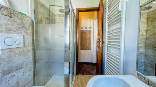 y baño con ducha acristalada y lavamanos. en Appartamento Winter Garden - Affitti Brevi Italia, en Bardonecchia