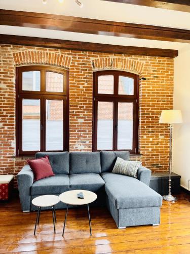 a living room with a blue couch and a brick wall at Charmante Ferienwohnung Greta in Norden