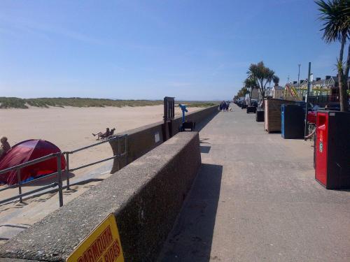 a sandy beach with a fence and a sidewalk at Tal Y Don Hotel in Barmouth