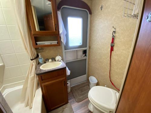 a small bathroom with a toilet and a sink at Water Front Tracer RV by Glampers Camp in Port Charlotte