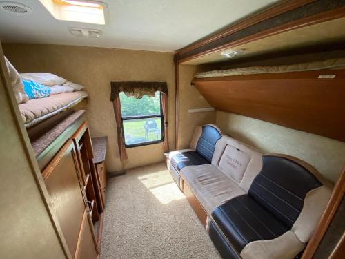 ポート・シャーロットにあるWater Front Tracer RV by Glampers Campの小さな客室で、二段ベッド2台、ソファが備わります。