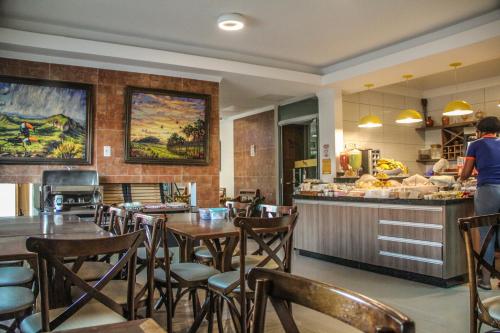 a restaurant with tables and chairs and a counter at Pousada Araras in Alto Paraíso de Goiás