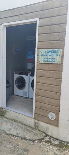 a laundry room with a washer and a washing machine at Camping Les Maraises in Saint-Martin-de-Ré