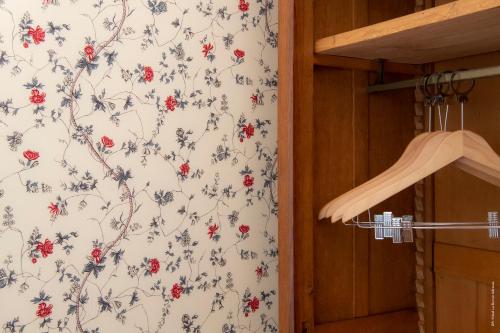 a bathroom with a wallpaper with red flowers at Hotel de Charme La Bonne Adresse - Logis hotels in Le Havre