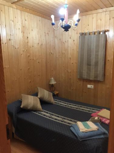 um quarto com uma cama numa parede de madeira em tranquilidad y en contacto con la naturaleza em Barahona