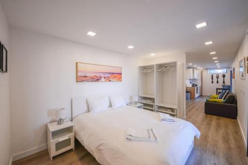 um quarto com uma grande cama branca num quarto em Monchique Islet View House T1 em Faja Grande