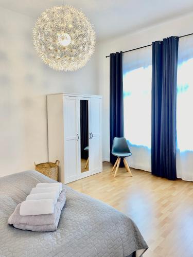1 dormitorio con cama y lámpara de araña en Charmante Ferienwohnung Greta, en Norden