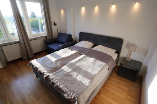 Apartament MGM Karmelicka في وارسو: غرفة نوم صغيرة بها سرير وكرسي