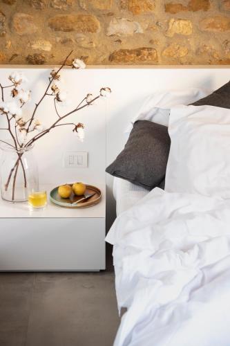 a white bedroom with a vase with a plate of fruit at Salvadonica in San Casciano in Val di Pesa