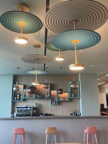 a restaurant with several lights hanging from the ceiling at H2C Hotel Milanofiori in Assago