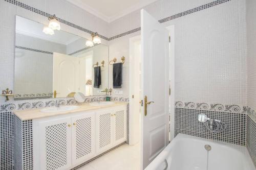 un bagno bianco con vasca e lavandino di Menorca Villa Marbella a Son Parc