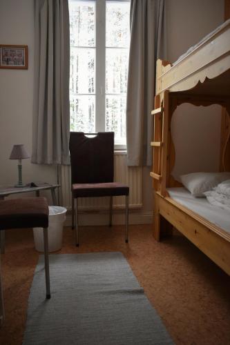 a bedroom with a bed and a chair and a window at Horrmundsgården i Sälen in Sälen