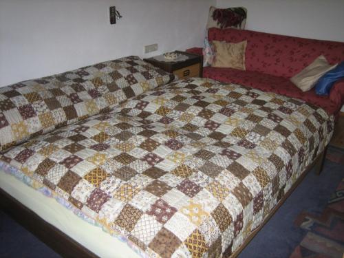 a bedroom with a bed with a checkered blanket at Haus Obinger in Reit im Winkl