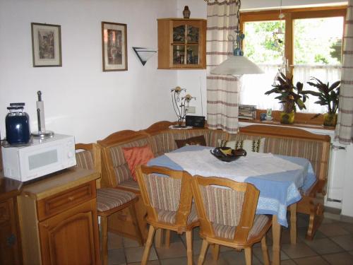 a kitchen with a table and chairs and a microwave at Haus Obinger in Reit im Winkl