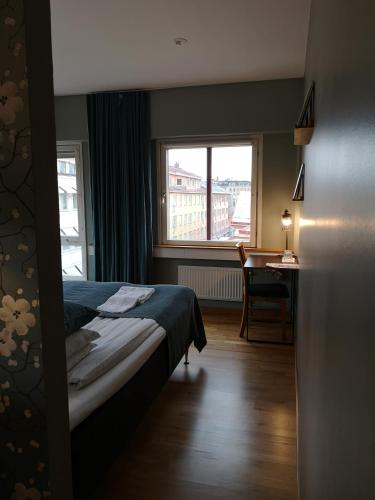 a bedroom with a bed and a desk and a window at Best Western Uppsala in Uppsala