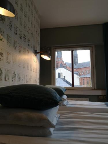 a bedroom with a bed with pillows and a window at Best Western Uppsala in Uppsala