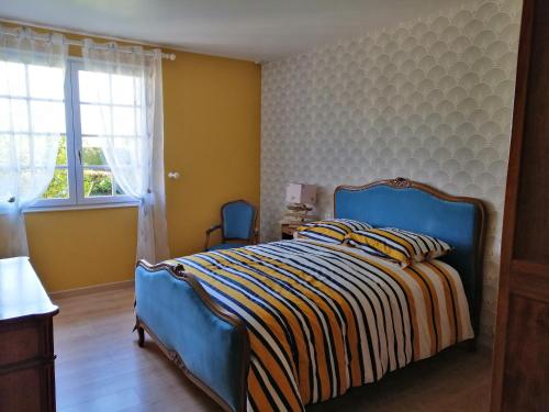 a bedroom with a blue bed and a window at Maison calme avec jardin, Petit-Caux in Bracquemont