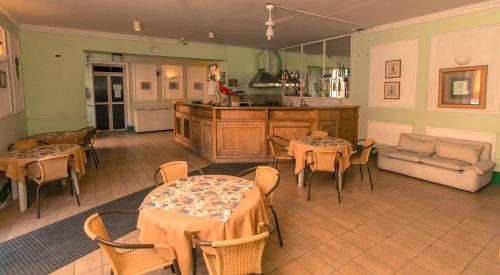 a living room with tables and chairs and a kitchen at Palace Hotel de Caxambu in Caxambu