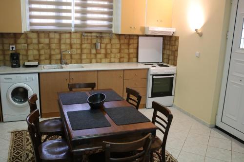 eine Küche mit einem Tisch und Stühlen sowie eine Küche mit einem Waschbecken in der Unterkunft POLYTIMI HOUSE in Kalavryta