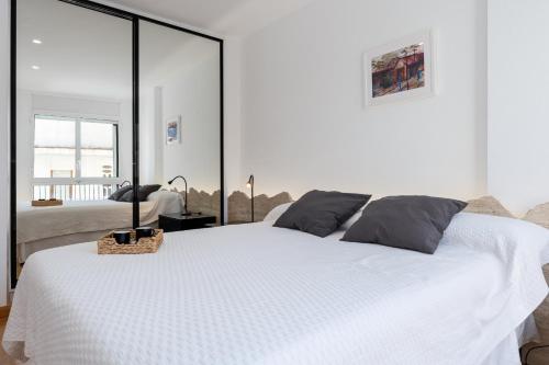 - une chambre avec un grand lit blanc et une grande fenêtre dans l'établissement Hauzify I Apartament Llaó, à L'Ametlla de Mar