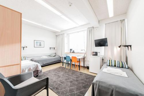 um quarto de hotel com duas camas e uma mesa em Forenom Hostel Espoo Otaniemi em Espoo