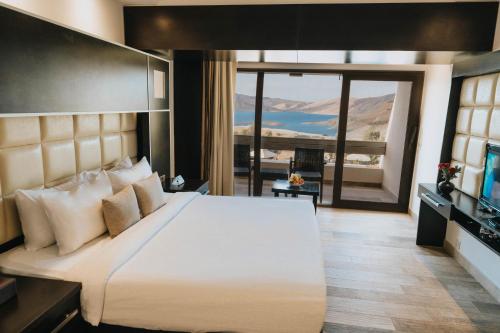 a bedroom with a large bed and a television at Ashur Hotel in Dokan