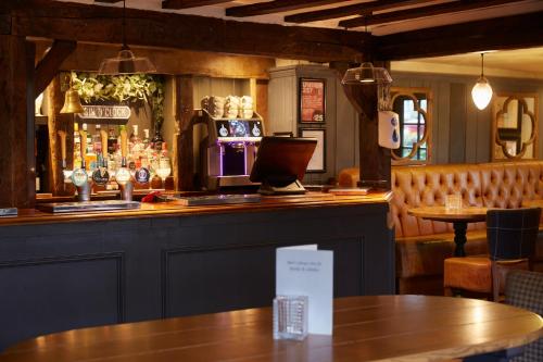 a bar in a restaurant with a counter and tables at Two Brewers by Chef & Brewer Collection in Kings Langley