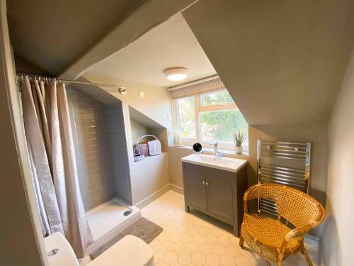 uma casa de banho no sótão com um chuveiro e um lavatório. em Churchside @ Mariners em Rhuddlan