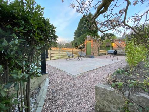 un giardino con patio, sedie e grill di Churchside @ Mariners a Rhuddlan