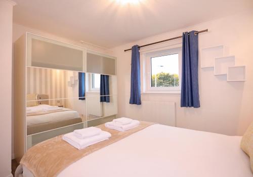 a bedroom with a bed and a large mirror at The South Maybury Residence in Edinburgh