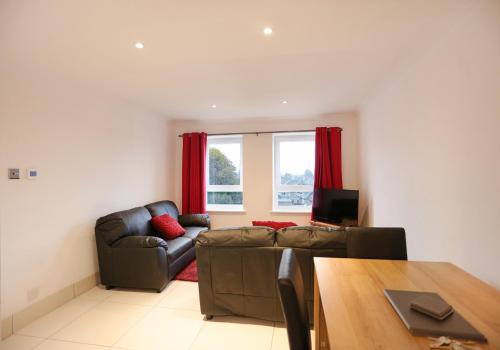 a living room with a couch and a table at The South Maybury Residence in Edinburgh