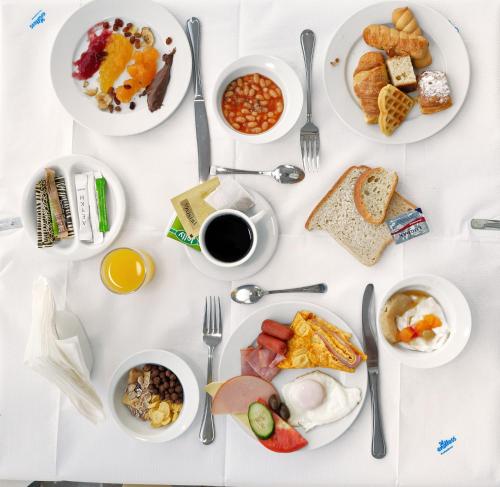 a white table topped with plates of breakfast foods at Hotel Punta in Punta