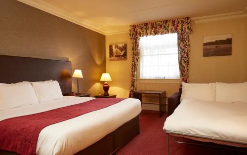 a hotel room with two beds and a window at Two Brewers by Chef & Brewer Collection in Kings Langley