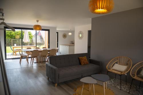 un salon avec un canapé, une table et des chaises dans l'établissement Les Lodges de Beg Leguer - côte de granit rose, à Lannion