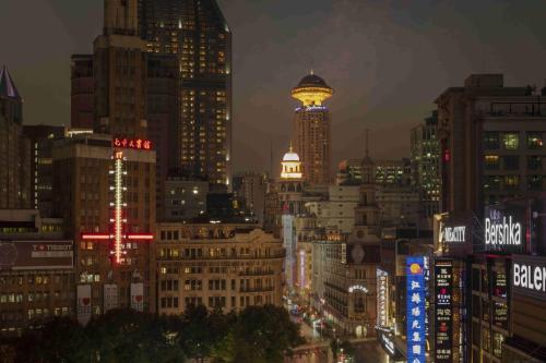 une vue sur la ville la nuit avec de nombreux bâtiments dans l'établissement Radisson Blu Hotel Shanghai New World, à Shanghai