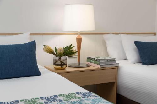 a bedroom with two beds and a table with a lamp at Sails Port Macquarie by Rydges in Port Macquarie