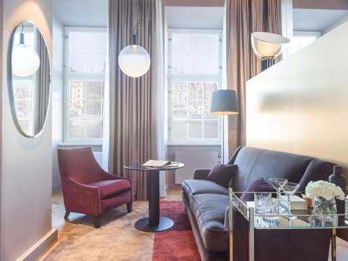 a living room filled with furniture and a window at Radisson Collection, Strand Hotel, Stockholm in Stockholm