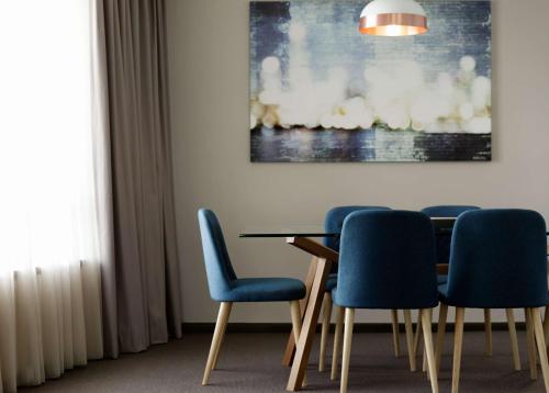 a living room with chairs and a table at Rydges Parramatta in Sydney