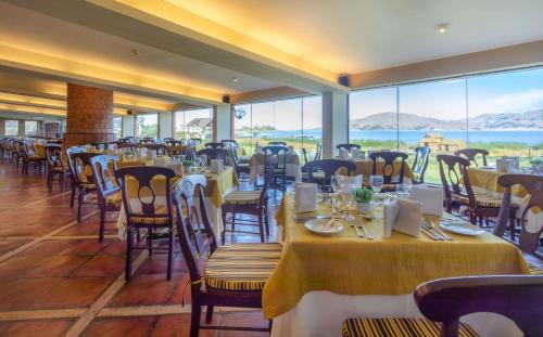 a restaurant with tables and chairs with a view of the ocean at Sonesta Posadas del Inca Puno in Puno